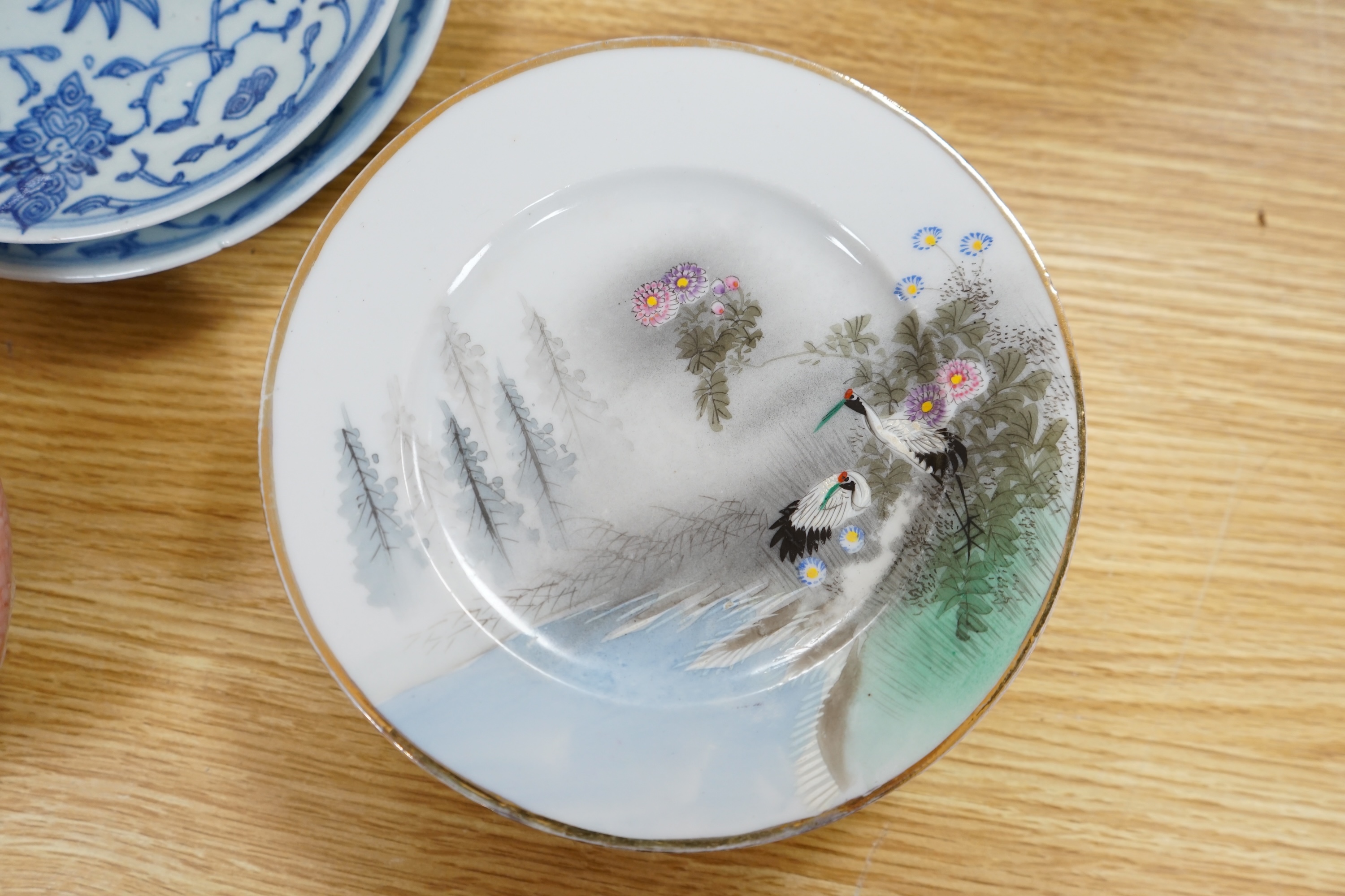 Two 19th century Chinese blue and white dishes together with a set of Japanese dishes, hand painted with storks, largest 19cm in diameter. Condition - fair to good